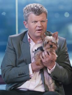 Adrian Chiles holding Alexandra Burke's dog.