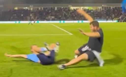 Screenshot of two men falling on a soccer field.