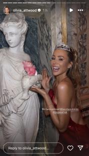 Olivia Attwood at a party, posing with a statue and a pink pig plushie.