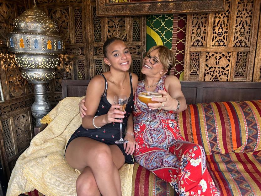 Lily King and her mother, Aicha King, seated together holding drinks.
