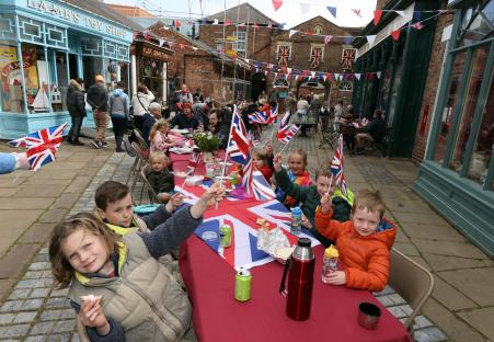 Families celebrating VE Day's 80th anniversary with Union Jack flags.
