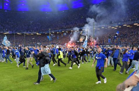 Hamburger SV fans celebrating on the pitch.