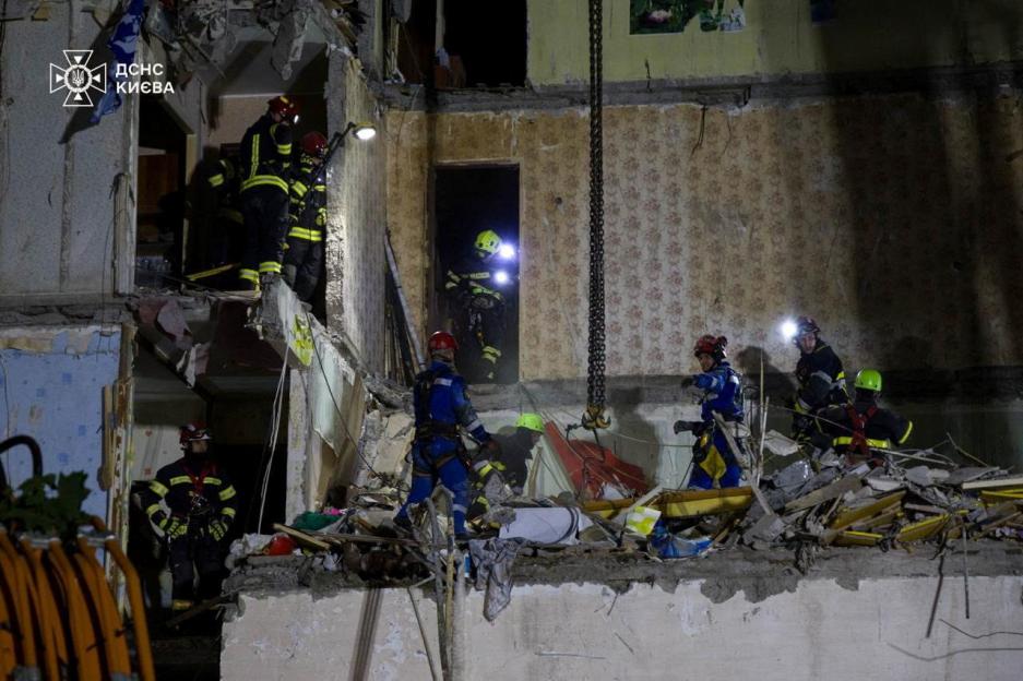 Rescuers searching for survivors in a damaged apartment building.