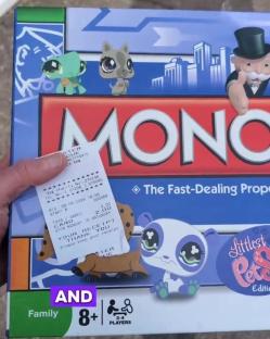 A hand holds a receipt and a Little Pet Shop edition of Monopoly.