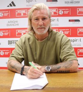 Robbie Savage signing a contract.