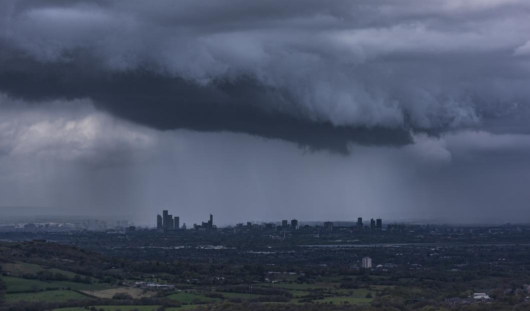 Manchester skyline under a stormy sky.