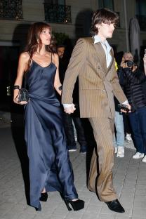 Cruz Beckham and a woman holding hands while leaving a hotel.
