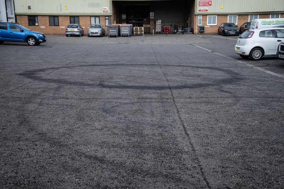 Tire marks in a ring on a large paved area in Flitwick, Bedfordshire, indicating a "ring of fire" event.