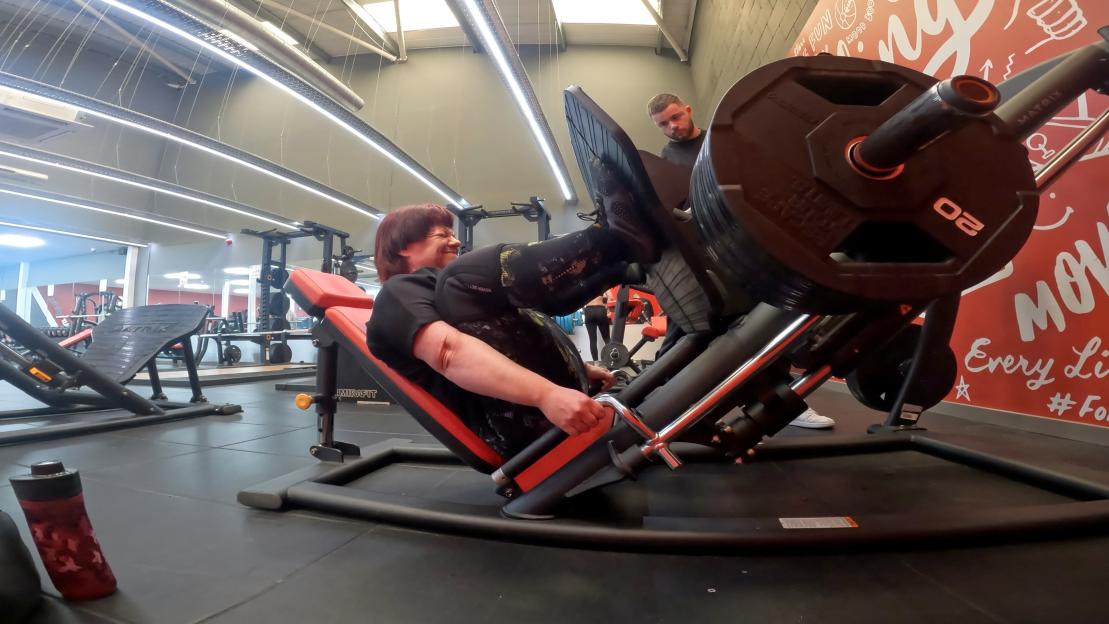 Woman using leg press machine at the gym.