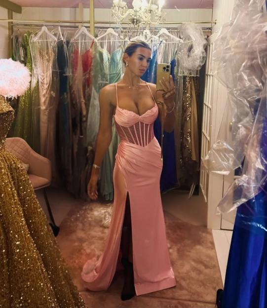 Christine McGuinness posing in a long pink dress with a thigh-high slit and a sparkling bodice.