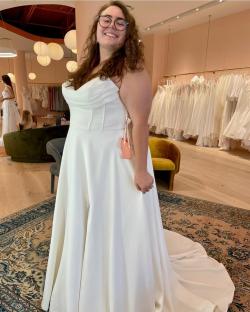 Woman in a white wedding dress in a bridal shop.