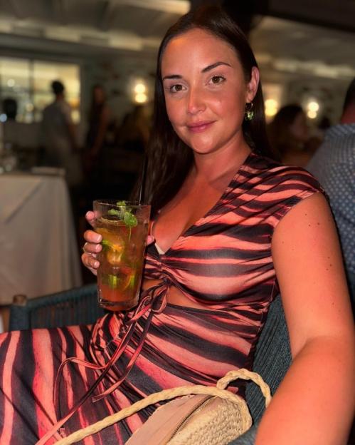 Woman in striped dress holding a cocktail.