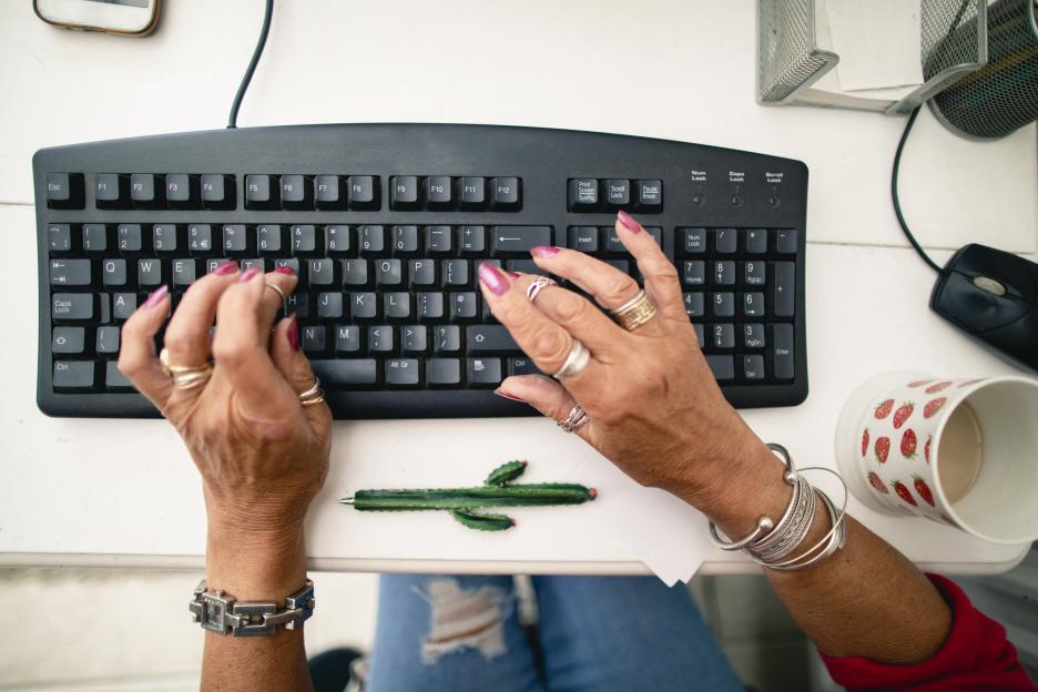 Senior woman's hands typing on a keyboard.