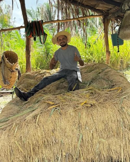 Reinaldo da Silva Melo, the "King of Juquira" influencer, sitting on a pile of harvested grain.