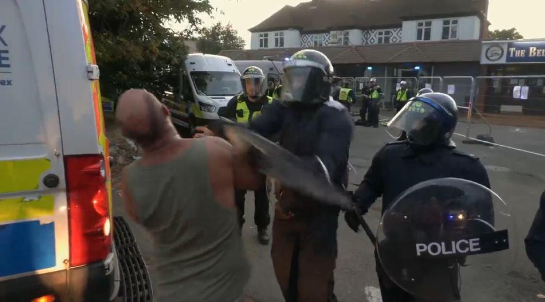 Moment riot cops smash shield into man’s face and knock his teeth out in clash after migrant ‘sexually assaulted’ girl