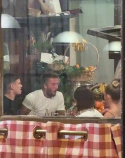 The Beckham family dining at a restaurant.