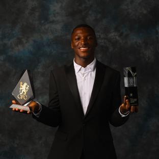 Moisés Caicedo holding two Chelsea awards.