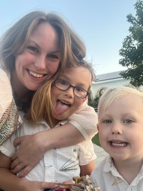 A woman hugging her two sons.
