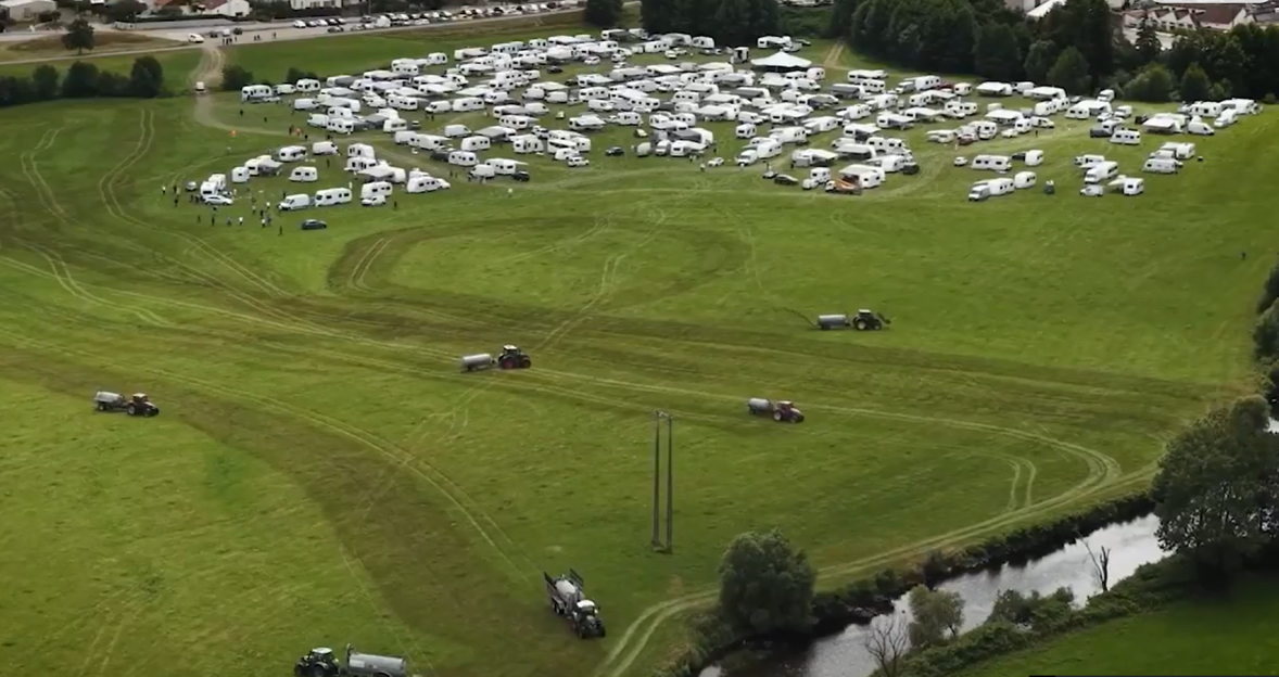 Aerial view of numerous caravans parked in a field.