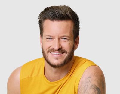 Portrait of a smiling man in a yellow tank top.