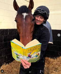 Woman in riding helmet reading