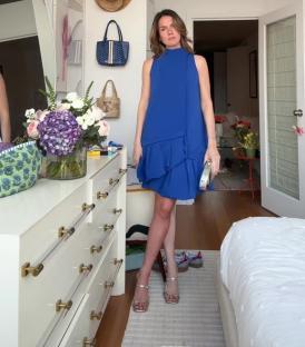Woman in blue dress realizing she only tanned one leg.