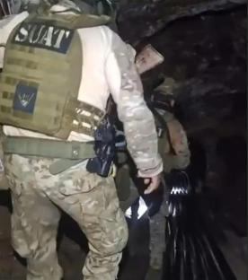SWAT officers recovering bodies from a mine.