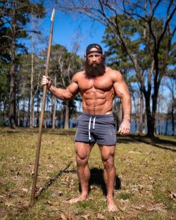 Brian Johnson, known as the Liver King, holding a spear.