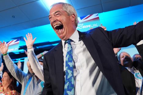 Nigel Farage celebrating with Reform UK party candidates at a campaign event.