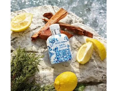 Dolce & Gabbana Light Blue Summer Vibes perfume bottle with lemons and wood.
