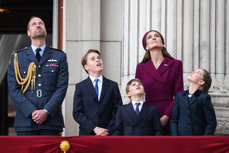 Prince William, Princess Catherine, and their three children watching a flypast from Buckingham Palace balcony.
