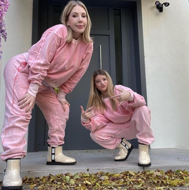 Katherine Ryan and her daughter Violet posing in matching pink tracksuits and boots.