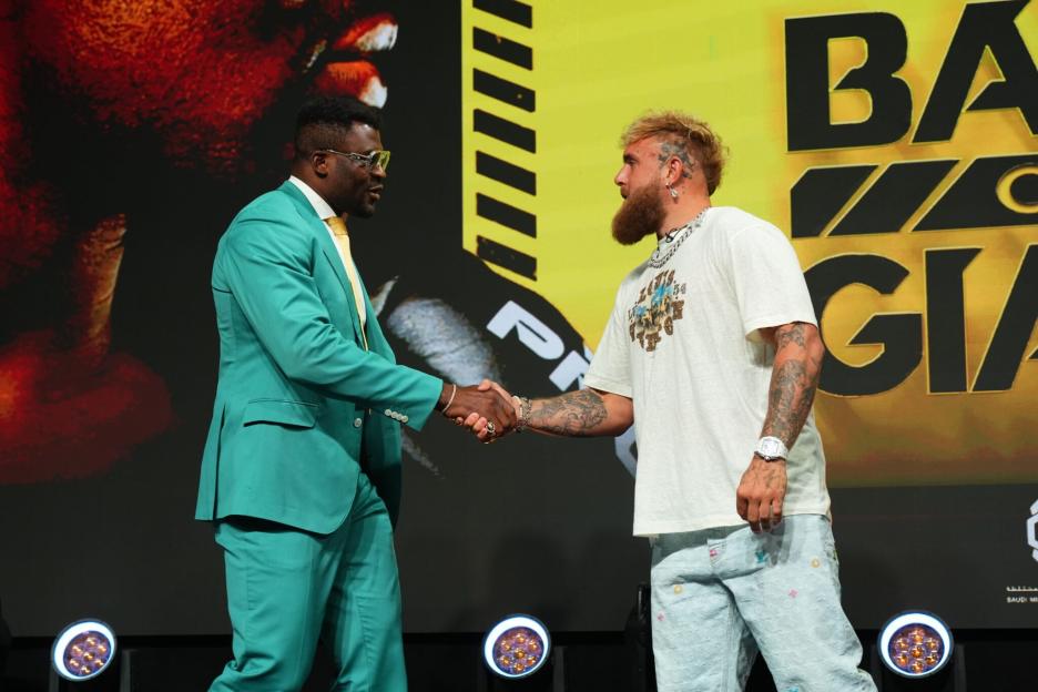 Francis Ngannou and Jake Paul shake hands.