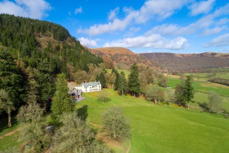 an aerial view of a house in the middle of a field