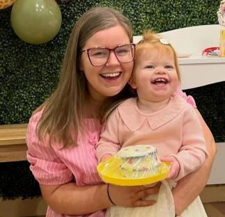 A mother and her toddler daughter at a birthday party.