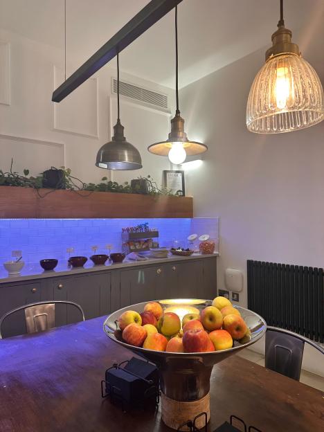 A large bowl of apples on a table with a buffet in the background.