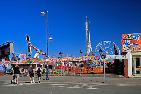 Barry Island Pleasure Park with rides and people walking by.