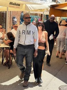 Kanye West and Bianca Censori walking with her sister, holding hands.