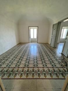 Empty room with patterned tile floor and doors leading to balconies.