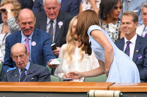 Stan Smith presents Kate Middleton with a signed baby shoe at Wimbledon.
