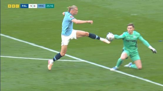 Soccer player kicking the ball past the goalie.