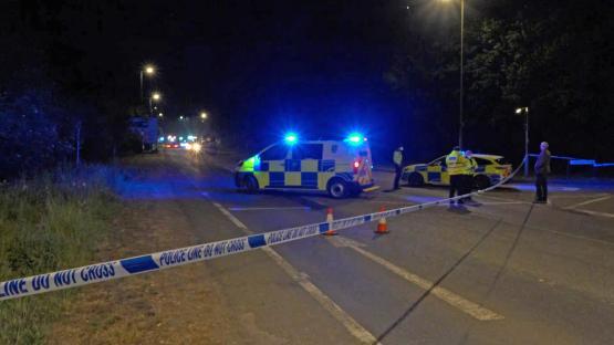 Emergency services at night at a scene marked with police tape.