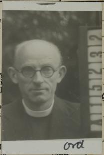 Black and white photo of a man in clerical collar.