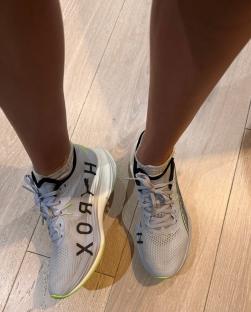 Pair of gray and white running shoes on a wood floor.