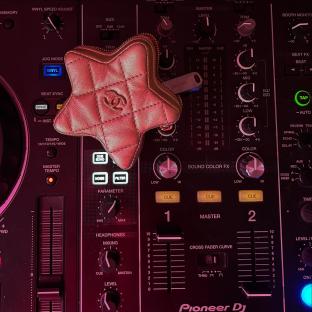 Star-shaped Chanel purse on a Pioneer DJ mixer.