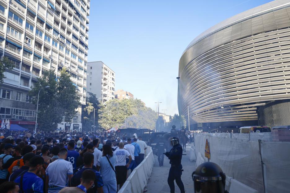 Supporters of Olympique de Marseille arriving at the Santiago Bernabeu stadium, with police presence.