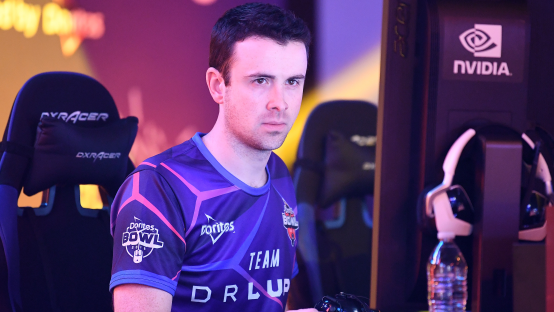 A man in a Doritos Bowl esports jersey sits in a gaming chair.