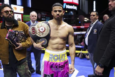 Boxer Rolly Romero holding a championship belt.