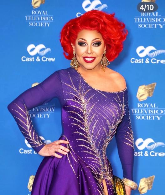 Drag queen in purple dress at Royal Television Society event.