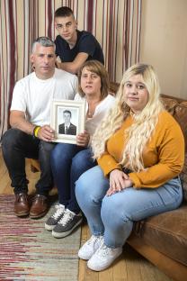 Family holding a photo of their deceased son.
